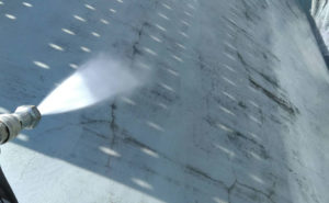 高圧洗浄で屋根や外壁をきれいにします。劣化して塗膜面が剥がれ、ひび割れが見られます。