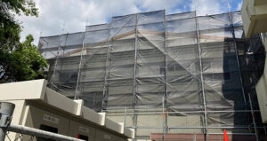 武道場に足場を架け、飛散防止シートで覆います